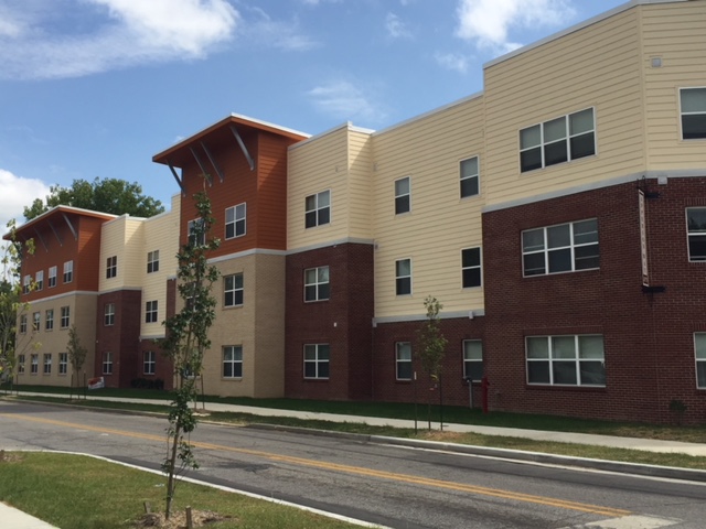 Photograph of the exterior of a three story apartment building.