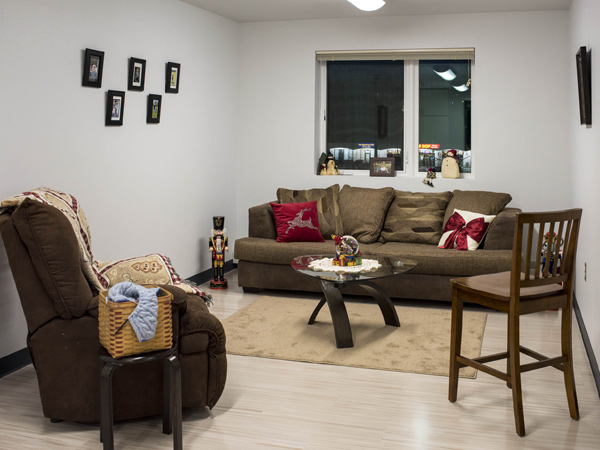 Image of an apartment living room with a couch, recliner, and chair.