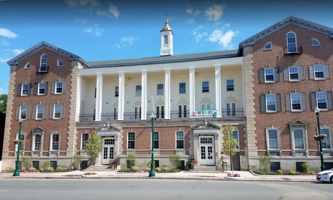 The façade of the multistory Capital YMCA building, featuring columns lining the balcony above the first floor.