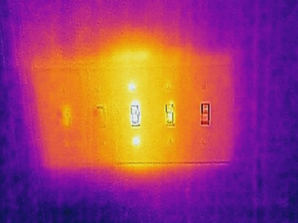Thermal image of a light switch in operation and with visible electricity.