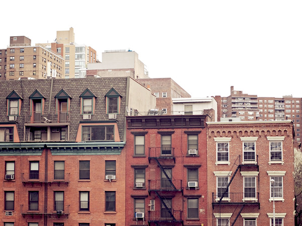 Photograph of multistory, multifamily residential buildings with fire escapes in New York City.