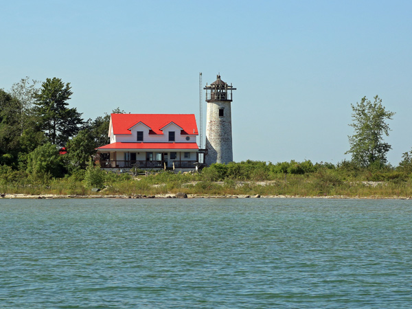 Image of a house and a lighthouse along Lake Huron’s Saginaw Bay.