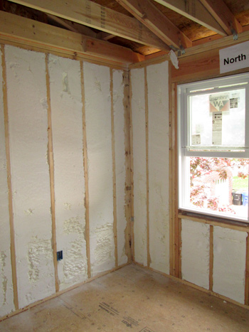 Image displaying foam insulation in unfinished walls between studs.