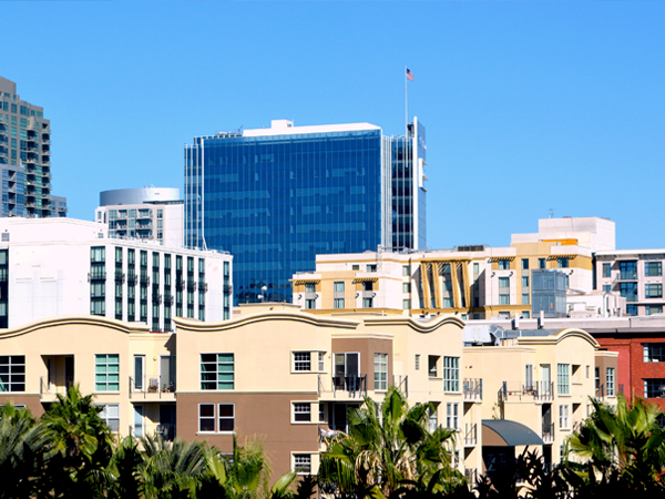 Photo of skyscrapers and buildings with trees in the foreground.