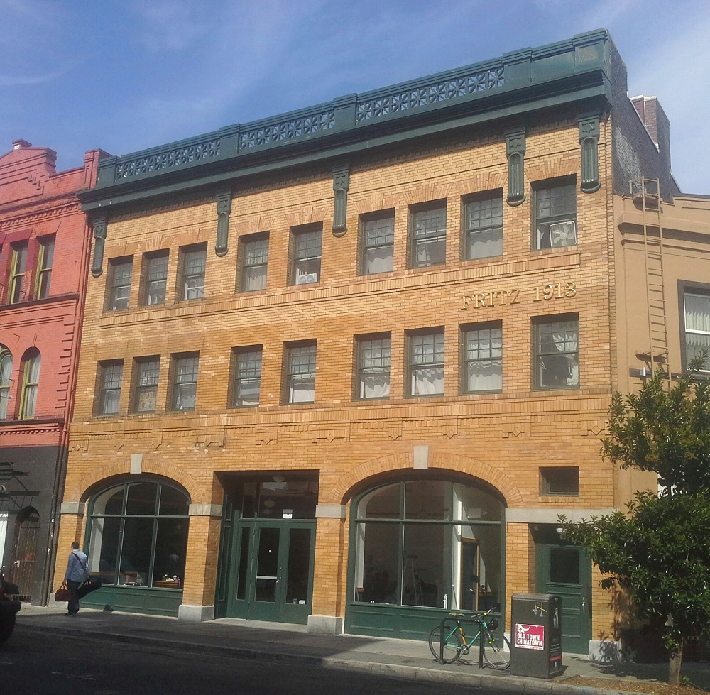 Photograph of the front façade of a three-story yellow-brick building.