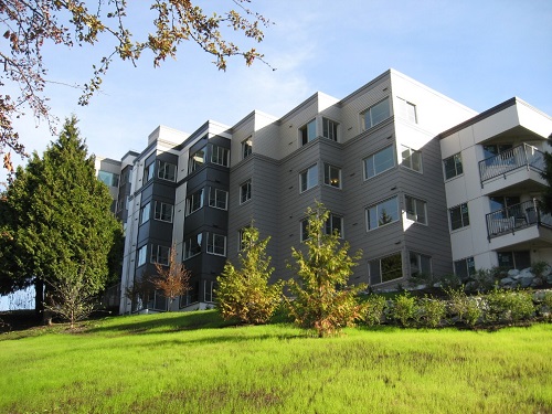 Photograph across a landscaped area of the rear of a six-story building.