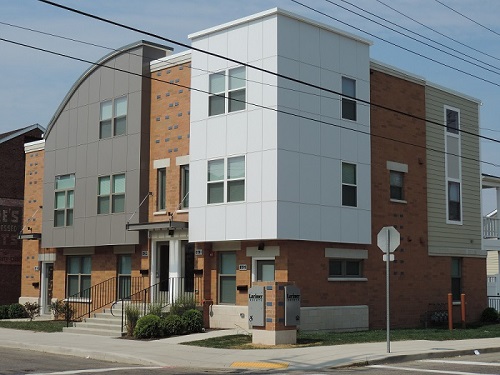 Photograph of two façades of a three-story residential building.  