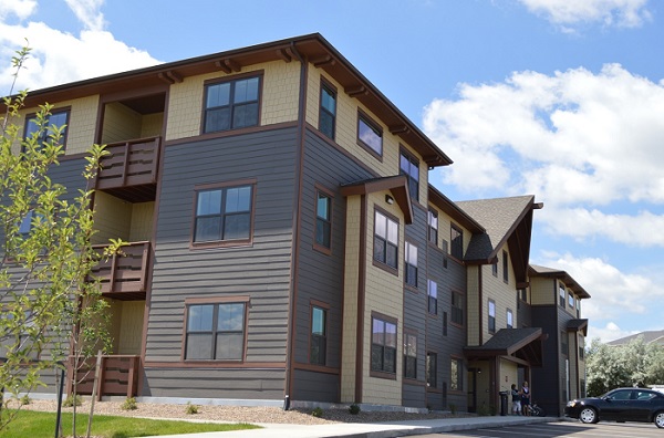 Photograph of the front and side façades of a three-story apartment building.