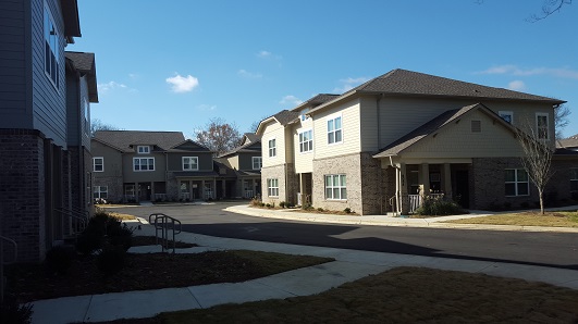 Photograph of four townhouse buildings along a newly constructed street.