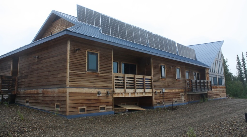 Photograph of a wing of the YKEALF building with an array of solar panels on the roof.