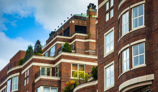 Photograph of the upper stories of a brick multifamily building.