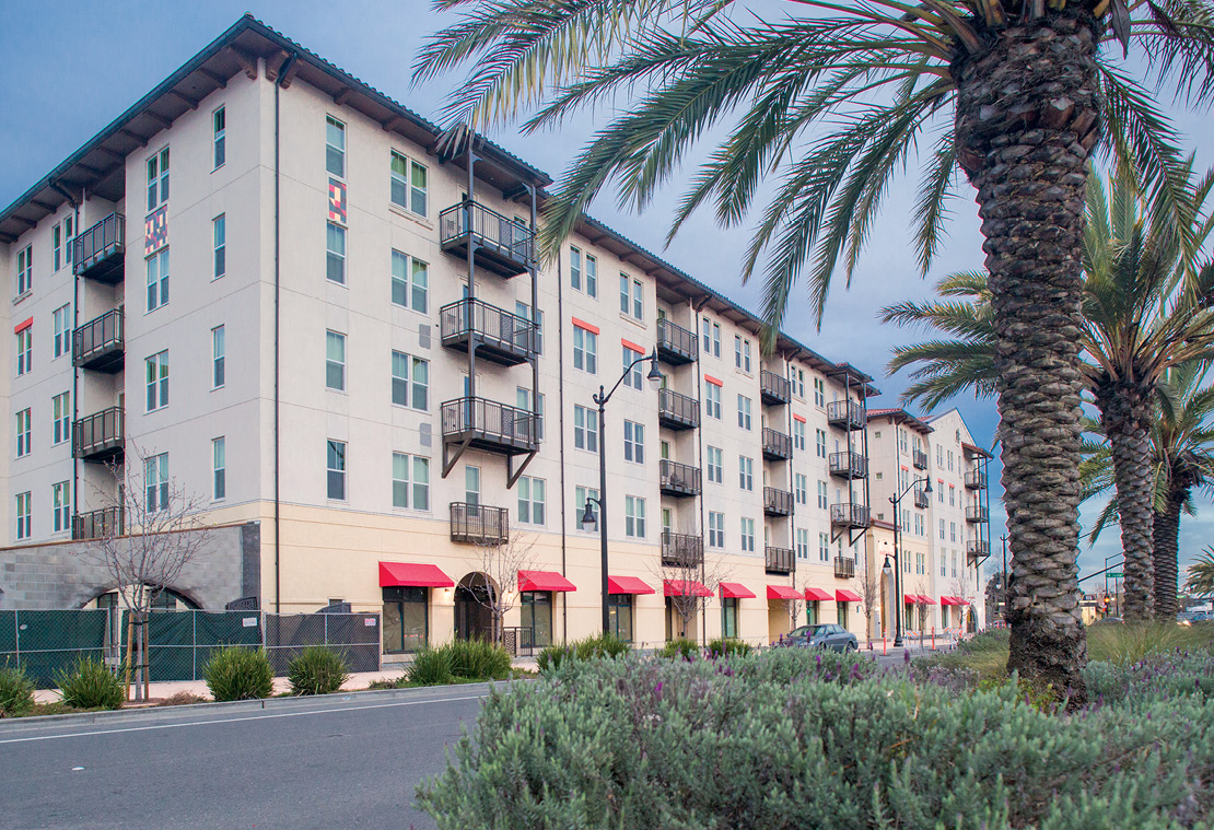 Photo shows two sides of a five-story multifamily building.