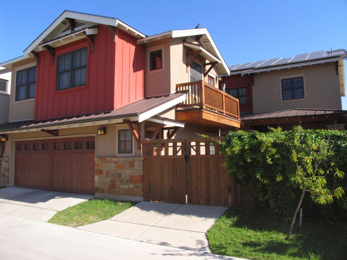 Front facade of a single-family home with garage facing the street and a cottage housing unit in the immediate background.