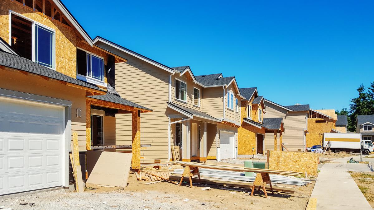 A row of four single-family homes under construction.