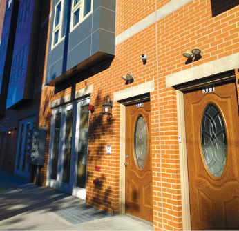 Photo shows the first floor facade of a multistory building with doors with zero-step entries.