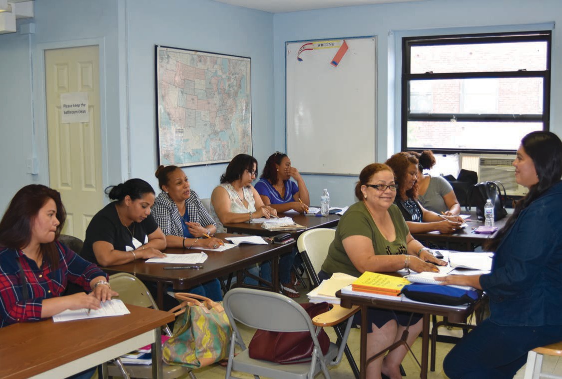 A group of women seated at tables listening to an instructor.