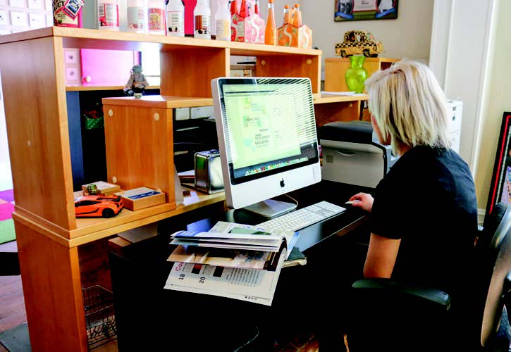 A young woman working on a computer at a desk.