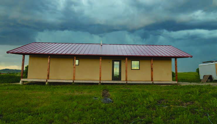 Photo shows a single house constructed with straw bale design.