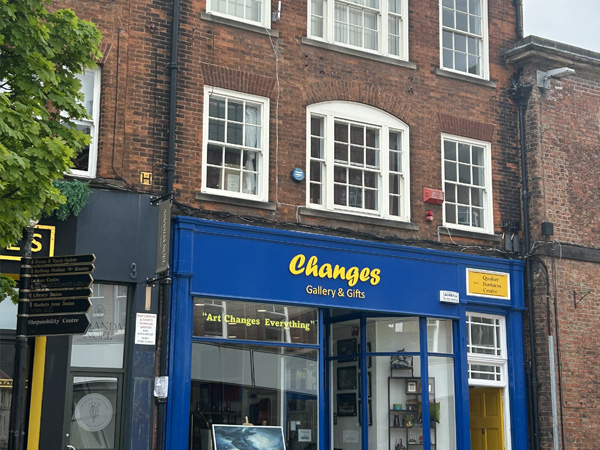 Exterior image of a ground-level shop in a three-story brick building.