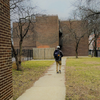  A student walking in a courtyard.
