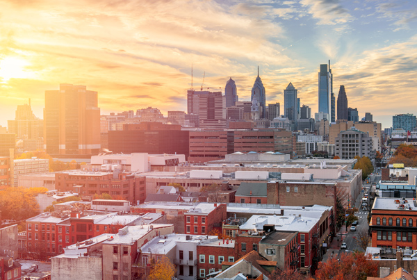 View of a city with skyscrapers at sunset.