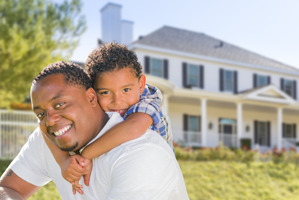 African American father carrying his son on his back, with a house in the background.