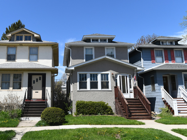 Photo showing a row of houses and blue sky in the background.