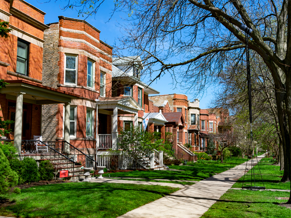 Image of brick row houses on a tree-lined street.