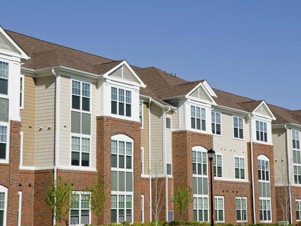 A photo of a three-story multifamily apartment building.