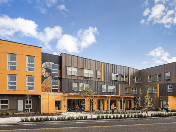 Photograph of building façade and exterior plaza with landscaping along street. Photograph of building façade and exterior plaza with landscaping along street.