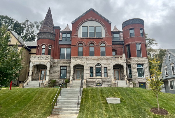 Three-story Queen Anne style residential structure with three entrances. 