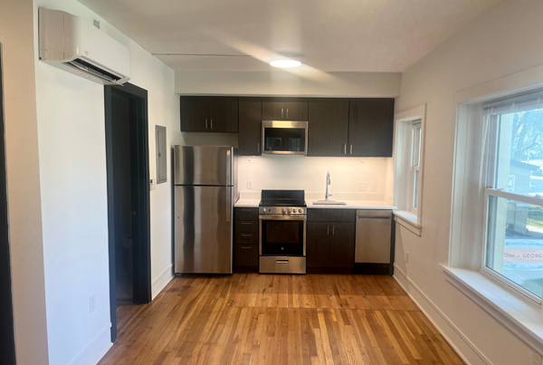 Kitchen with a refrigerator, oven, microwave, and dishwasher and wood flooring.