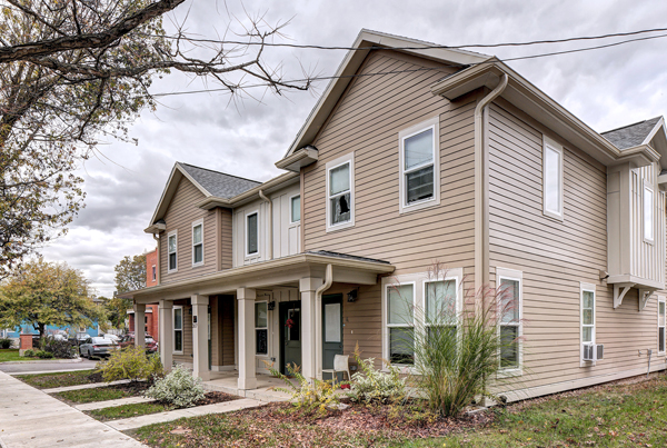 A pair of modern townhomes with beige siding.