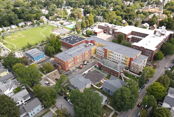 An aerial shot of the Founders Way development, which includes an L-shaped apartment building and several smaller standalone buildings.