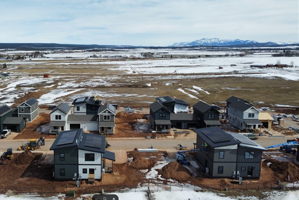 Aerial view of newly built single-family homes in snowy rural landscape.