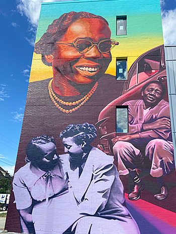 A mural on the façade of a four-story building.