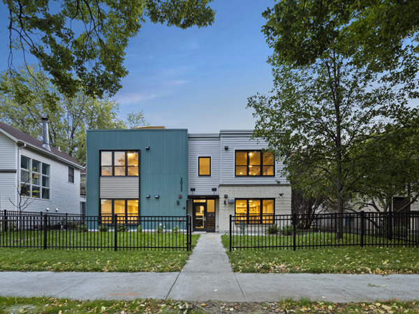 Exterior image of a modern, two-story apartment building at dusk.