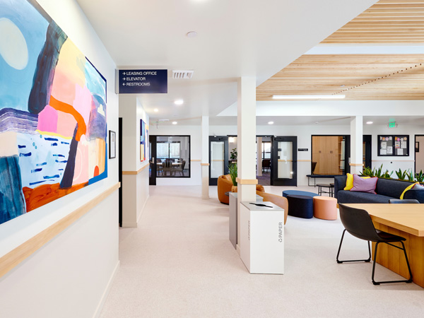 A common area in a modern apartment building decorated with colorful abstract paintings. 