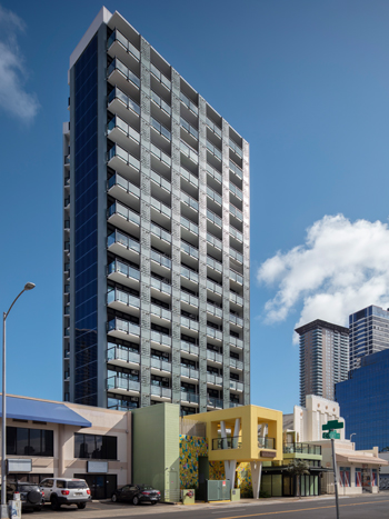 Tall narrow residential building with a two story shopping center in the front.