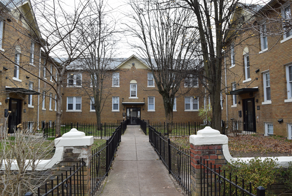 A walkway leading down to the entrance of a building, with additional buildings to the left and right.