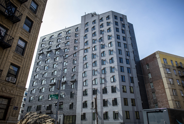 Exterior of a gray mid-rise apartment building.