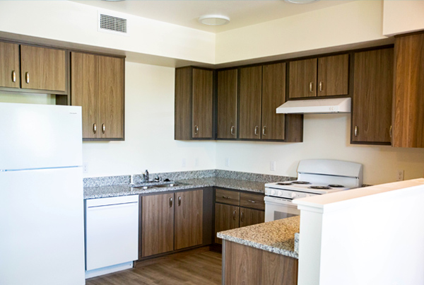 An interior kitchen with appliances and upper and lower cabinets.