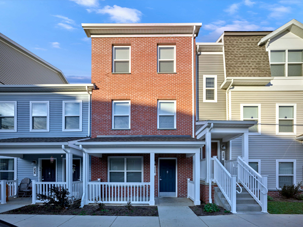  Image of three rowhouses with brick and clapboard exteriors.
