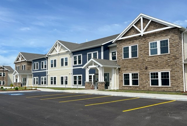 A two-story apartment building and empty parking spaces.