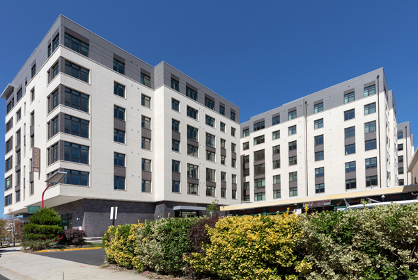 Exterior of a modern seven-story "F"-shaped apartment building.