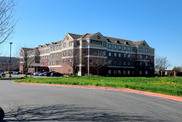 A four-story building with a sign reading "Staybridge Suites" on the façade.