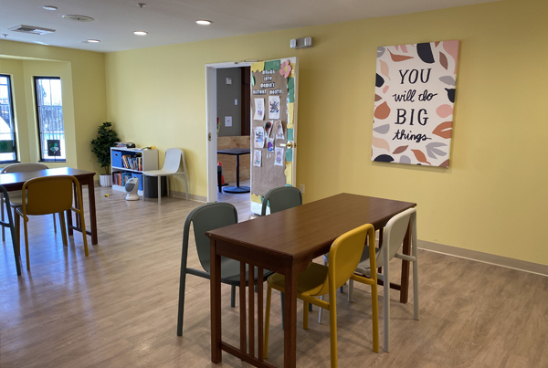 A room set up for afterschool programming, with decorations, books, tables, and chairs.