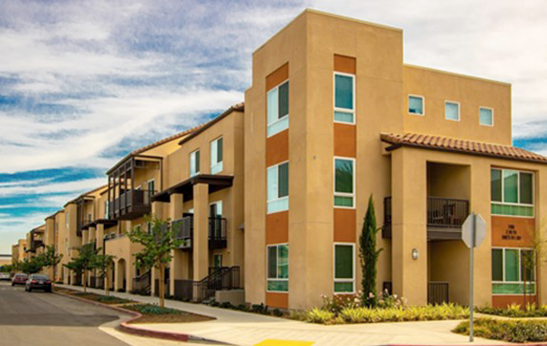 Photograph of a three-story residential building from the corner. 