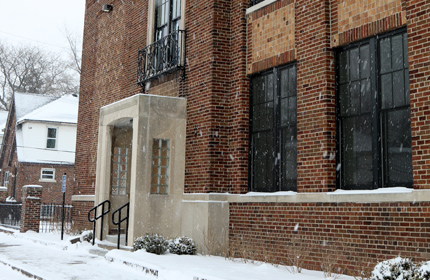 Photograph of the front façade of a two-story brick building with limestone accents.