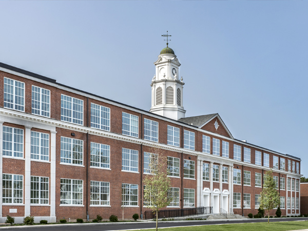 Photograph of perspective view of building façade with landscaping in the forefront.